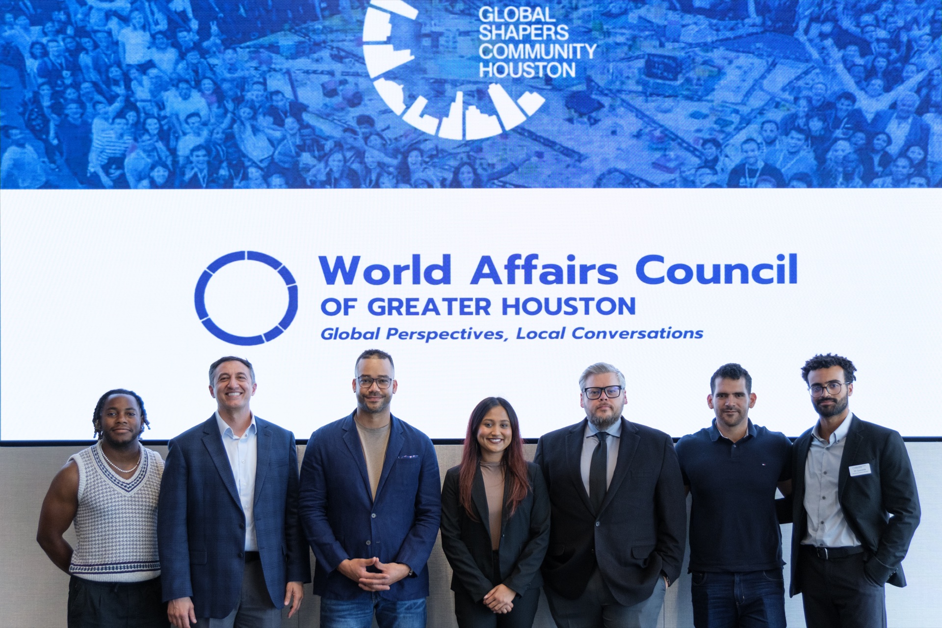 Debate participants and organizers standing together beneath the World Affairs Council of Greater Houston and Global Shapers Community Houston marks.